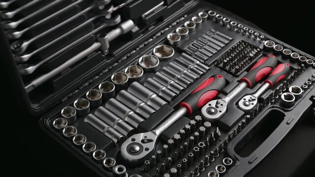 black tool box case opened by male worker hands in red clothes and using chrome tools