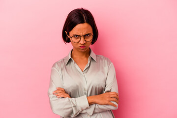Young mixed race woman isolated on pink background blows cheeks, has tired expression. Facial expression concept.