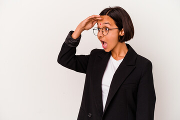 Young business Indian woman isolated on white background looking far away keeping hand on forehead.