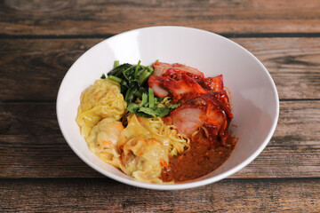 Shrimp dumpling with roasted pork with local thai tom yum spicy sauce on wood background