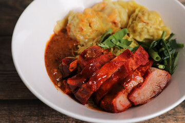 Shrimp dumpling with roasted pork with local thai tom yum spicy sauce on wood background