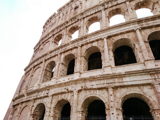 Fototapeta premium Colosseum outside marble arches part on white background. Iconic ancient monumental 3-tiered Roman amphitheater, gladiatorial games arena in center of Rome, Italy