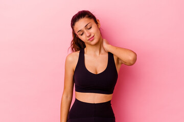 Young sport Indian woman isolated on pink background suffering neck pain due to sedentary lifestyle.