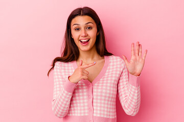 Young Indian woman isolated on pink background smiling cheerful showing number five with fingers.