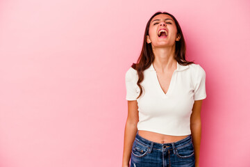 Young Indian woman isolated on pink background shouting very angry, rage concept, frustrated.