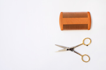 Comb and scissors isolated on white background.