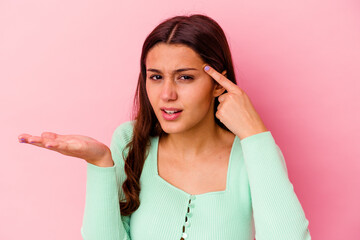 Young Indian woman isolated on pink background showing a disappointment gesture with forefinger.