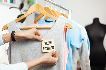 Slow fashion. Clothes on hangers in a shop showcase. Recycled organic apparel.