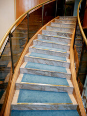 circular marble staircase with blue carpet