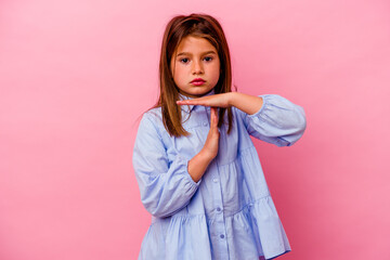 Little caucasian girl isolated on pink background showing a timeout gesture.