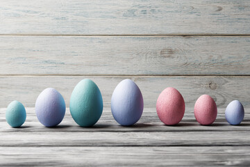 Various multicolored Easter eggs over light wooden background