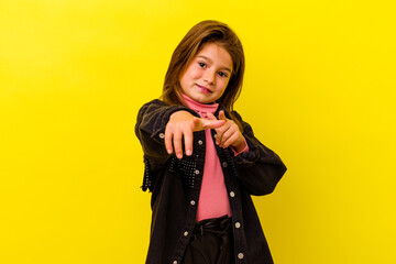 Little caucasian girl isolated on yellow background cheerful smiles pointing to front.