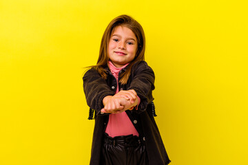 Little caucasian girl isolated on yellow background stretching arms, relaxed position.