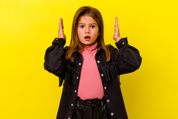 Little caucasian girl isolated on yellow background surprised and shocked.