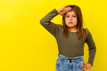 Little caucasian girl isolated on yellow background looking far away keeping hand on forehead.