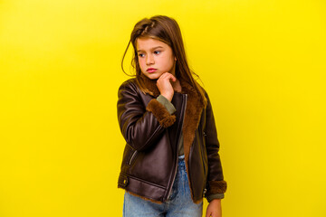 Little caucasian girl isolated on yellow background suffers pain in throat due a virus or infection.