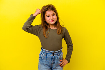 Little caucasian girl isolated on yellow background cheering carefree and excited. Victory concept.