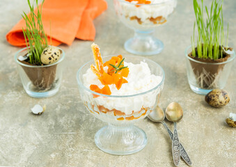 Finnish cottage cheese Easter dessert with whipped cream and dried apricots in glass bowls on a light concrete background. Happy Easter.