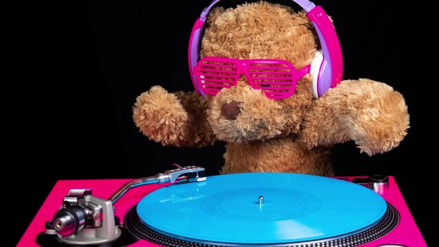 Teddy bear djing on turntables with headphones