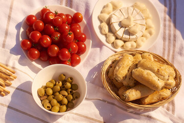 summer outdoor picnic with cherry, rollini, cheese, olives. top view