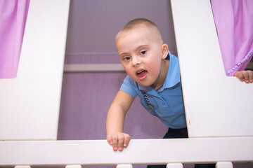 A boy with Down syndrome plays a role-playing game, a genetically ill disabled child in a doctor's...