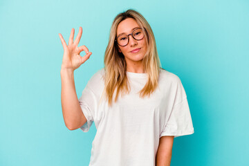 Young mixed race woman isolated on blue background cheerful and confident showing ok gesture.