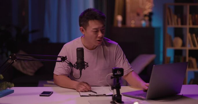 Asian handsome young man partici ates in online meeting with colleagues discussing business ideas for start-up company in the house. Lockdown. Social distance.