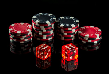 Dice with a maximum winning combination of twelve in poker on a black table and chips in the background