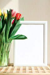 Poster with copy space in warm shades . Mockup of a wooden frame with tulips. White, minimalism. copy space. Mock up design.