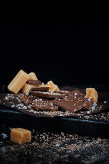 Chocolate with salted caramel on black background. Copy space for text 