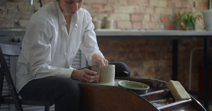 Ceramist sculpts on a potter's wheel, video from pottery workshop, potter makes ceramics in slow motion, 4k 60p Prores HQ 10 bit