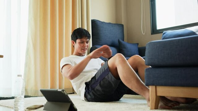 slow motion scene on young man in sit-up pattern workout on exercise mat at home gym in the morning for quarantine and lifestyle and healthy concept