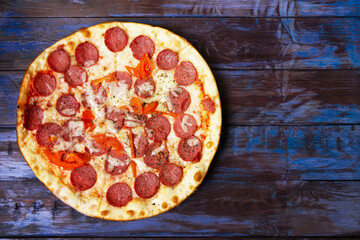 Pepperoni pizza with salami and mozzarella on wooden table.