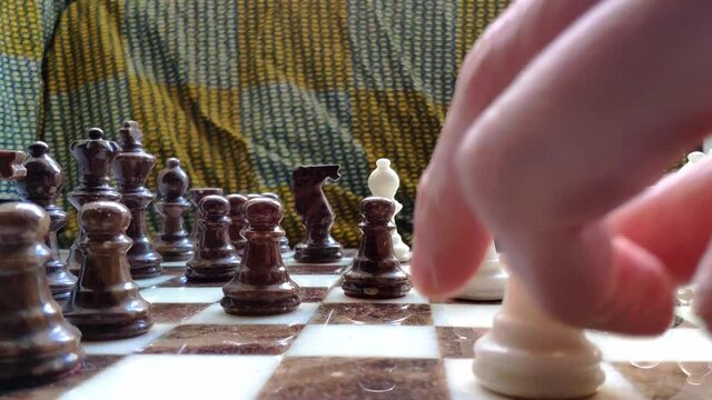 Close up at eye sight of marble chess game. Some pieces are placed on the board. These are put back on the starting position left ready for a new game.