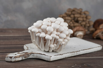 White beech mushroom on white desk and wood table.