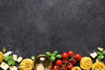 Tagliatele pasta, tomatoes, basil and parmesan cheese on a black concrete background. Ingredients for pasta with text space. Layout.