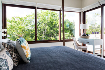Luxury bedroom in Tulum with a workspace and lush garden view with green vegetation