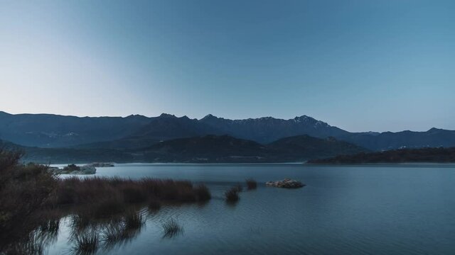 Time-lapse of stars passing over the mountains of San Parteo and Monte Grosso as dawn breaks at Lac de Codole in the Balagne region of Corsica at sunset