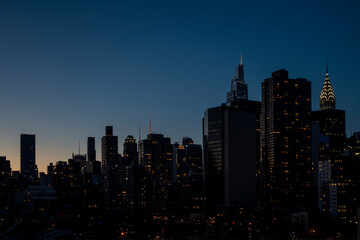 Naklejka premium New york city building night sky with lights and setting sun