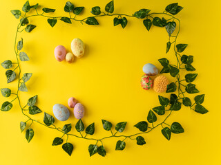 Easter eggs on a yellow background with green leaves