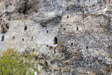 Ancient dwellings in the mountains. Kurtat Gorge in North Ossetia-Alania, Russia. Stone cave houses in the rocks. Dzivgis village in Fiagdon