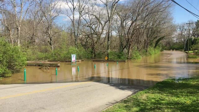 Flood water from Harpeth River covers Morton Mill Metro Greenway walking path in Bellevue, (Nashville) TN. Pan right to show flood water over Morton Mill Road, up to Bay Cove Trail. March 28, 2021.