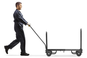 Worker in a uniform pushing an empty hand truck