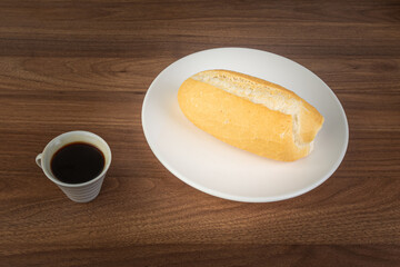 Brazilian Wheat Baked French Bread and coffee, on wooden table - top view.