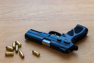 firearm, 40 caliber pistol in ammunition on wooden surface.