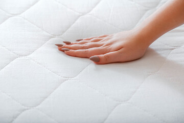 Female hand Pressing Testing mattress to Check softness. Choice comfortable mattress for sleep in...
