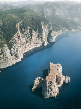 Aerial view of the rocky promontory and cliffs facing the Mediterranean Sea near Porto Flavia, Sardinia, Italy.