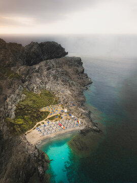 Aerial view of a small beach in a small bay along the promontory near La Pelosa town, Sassari, Sardinia, Italy.