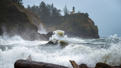 Cape Disappointment lighthouse waves crashing over the drift wood at Cape Disappointment State Park