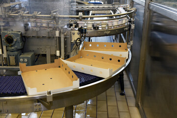 Automated production chain for the packaging of products for sale and consumption in cardboard boxes